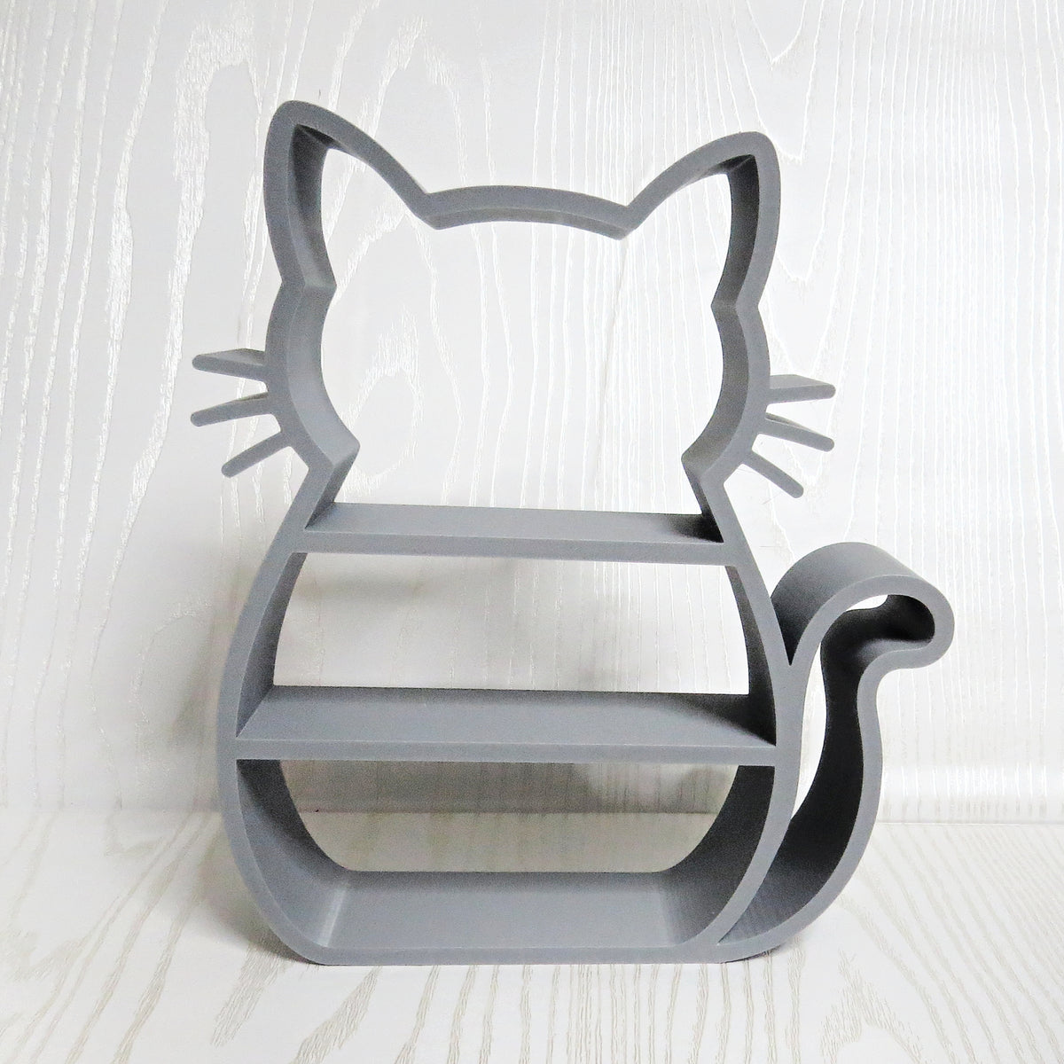 Gray cat shaped freestanding display shelf with open tiers, whiskers, and a curled tail