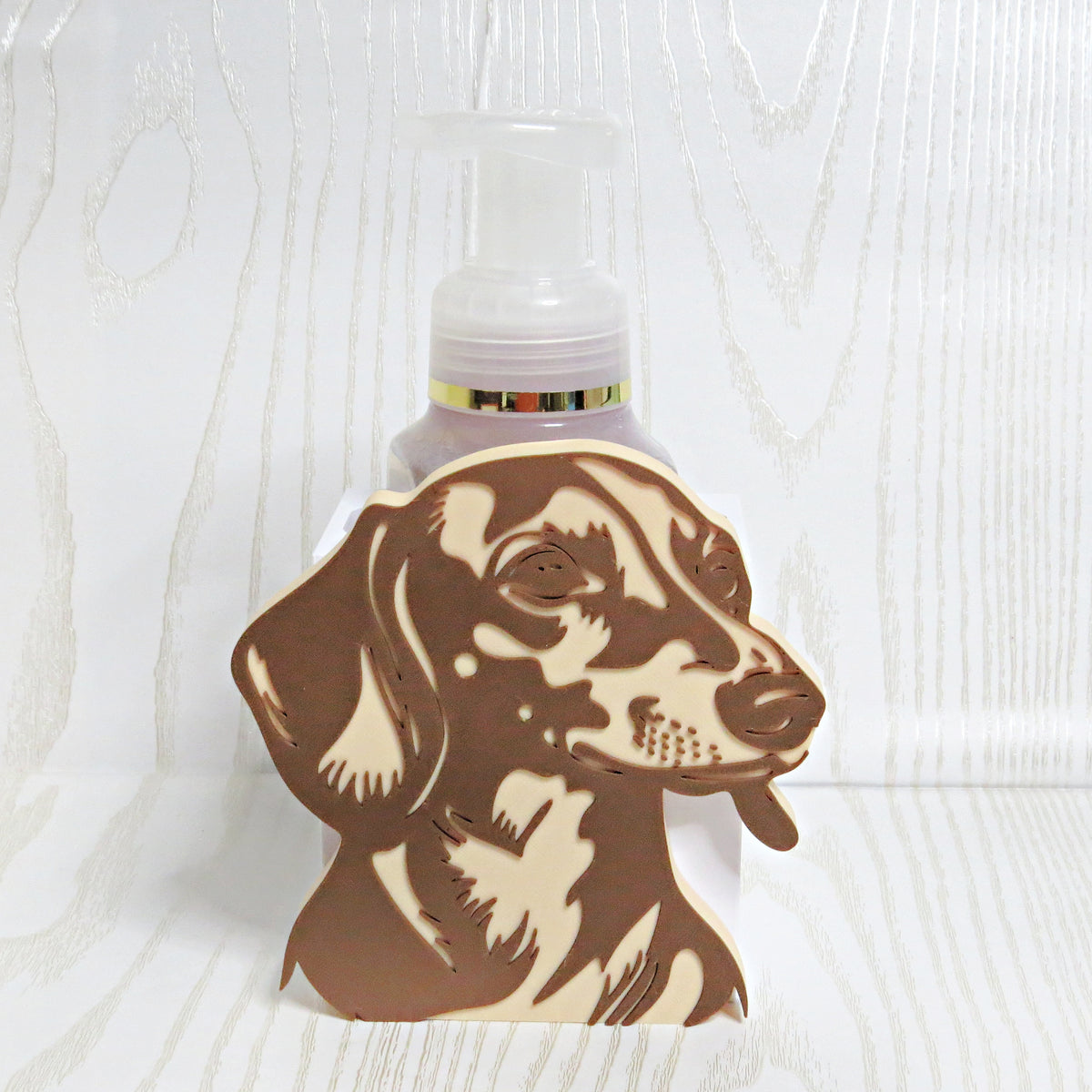 Brown and cream dachshund portrait foaming soap bottle holder with a soap bottle behind it