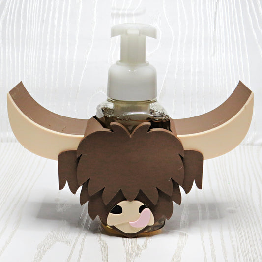 Highland cow foaming soap holder with long horns wrapped around a hand soap bottle rustic farmhouse bathroom countertop decor brown cow sink accessory