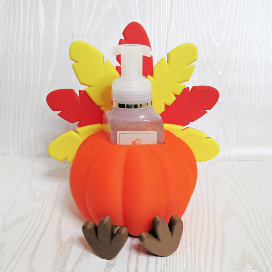 Orange pumpkin turkey shaped foaming soap bottle holder with red and yellow feathers for fall decor