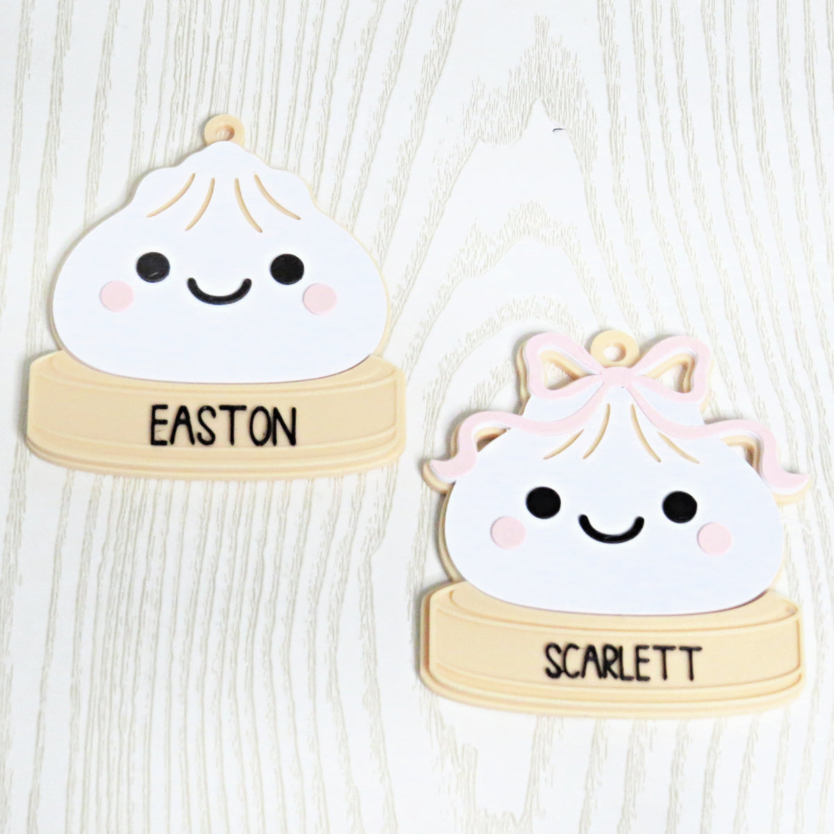 Personalized dumpling Christmas ornament with custom name, one plain and one with pink bow