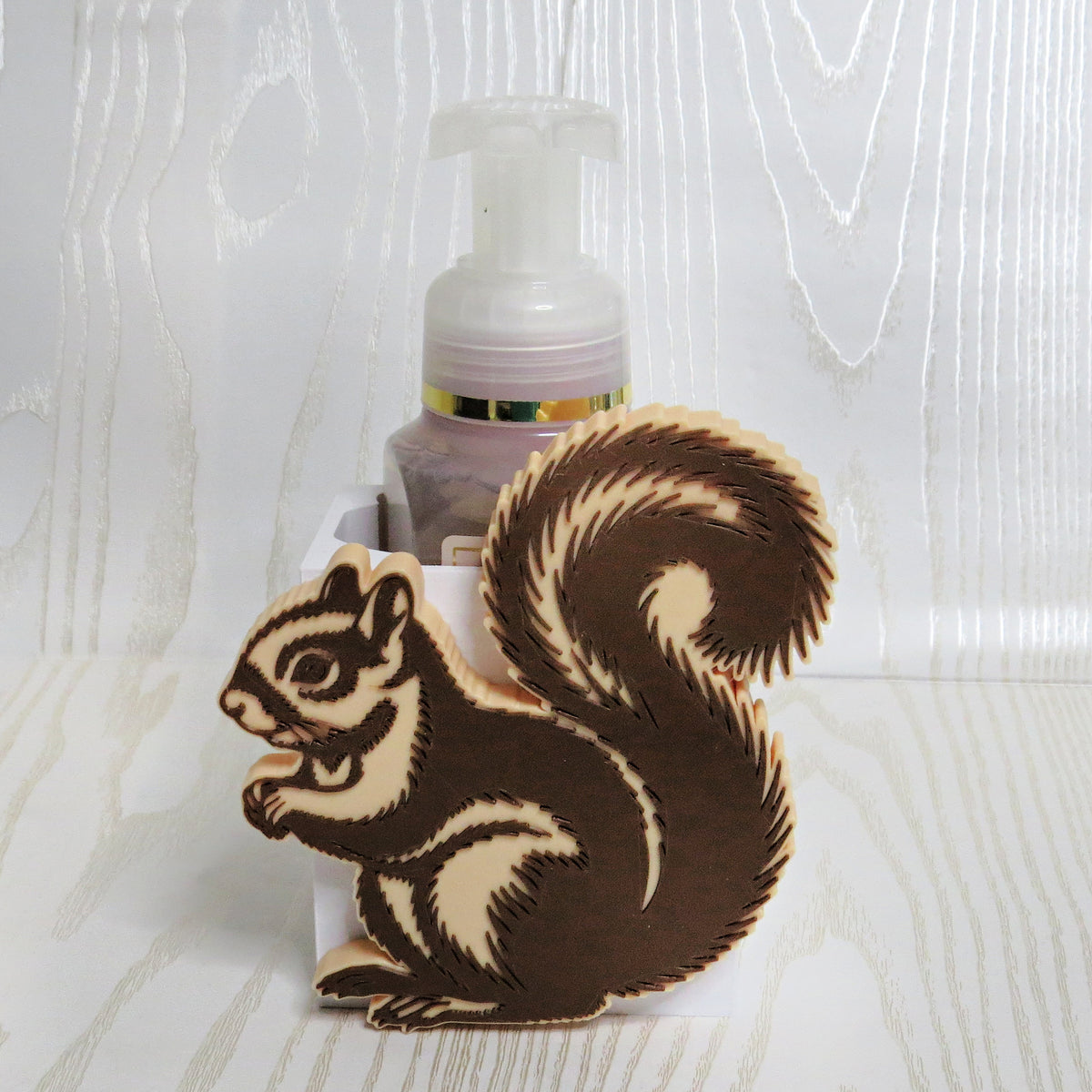 Brown and tan squirrel shaped foaming soap bottle holder with bushy tail for woodland fall decor