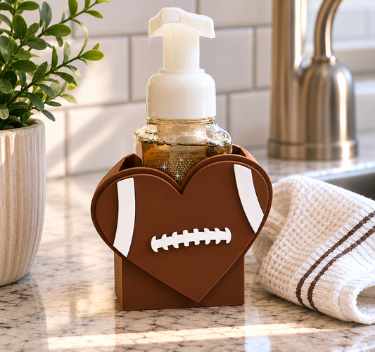 Football heart foaming soap holder designed for BBW foaming soap bottles displayed on a kitchen or bathroom countertop