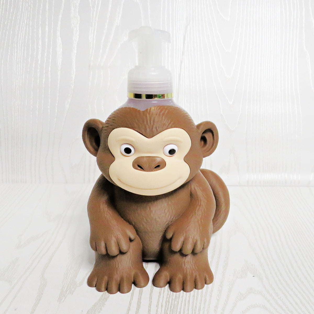 Cute brown monkey shaped foaming soap bottle holder with googly eyes for bathroom decor