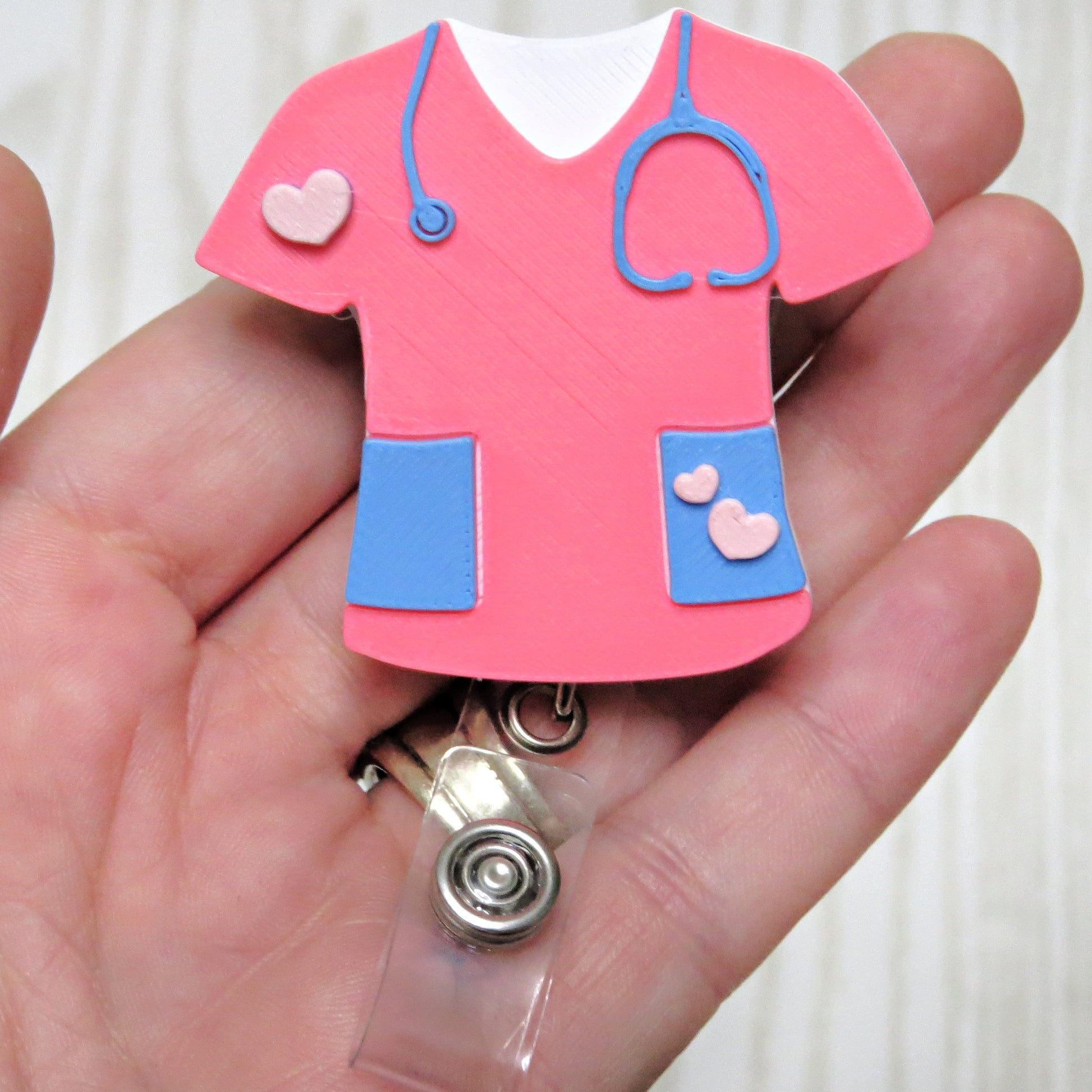 Pink nurse scrub retractable badge reel holder with stethoscope and heart accents for healthcare workers