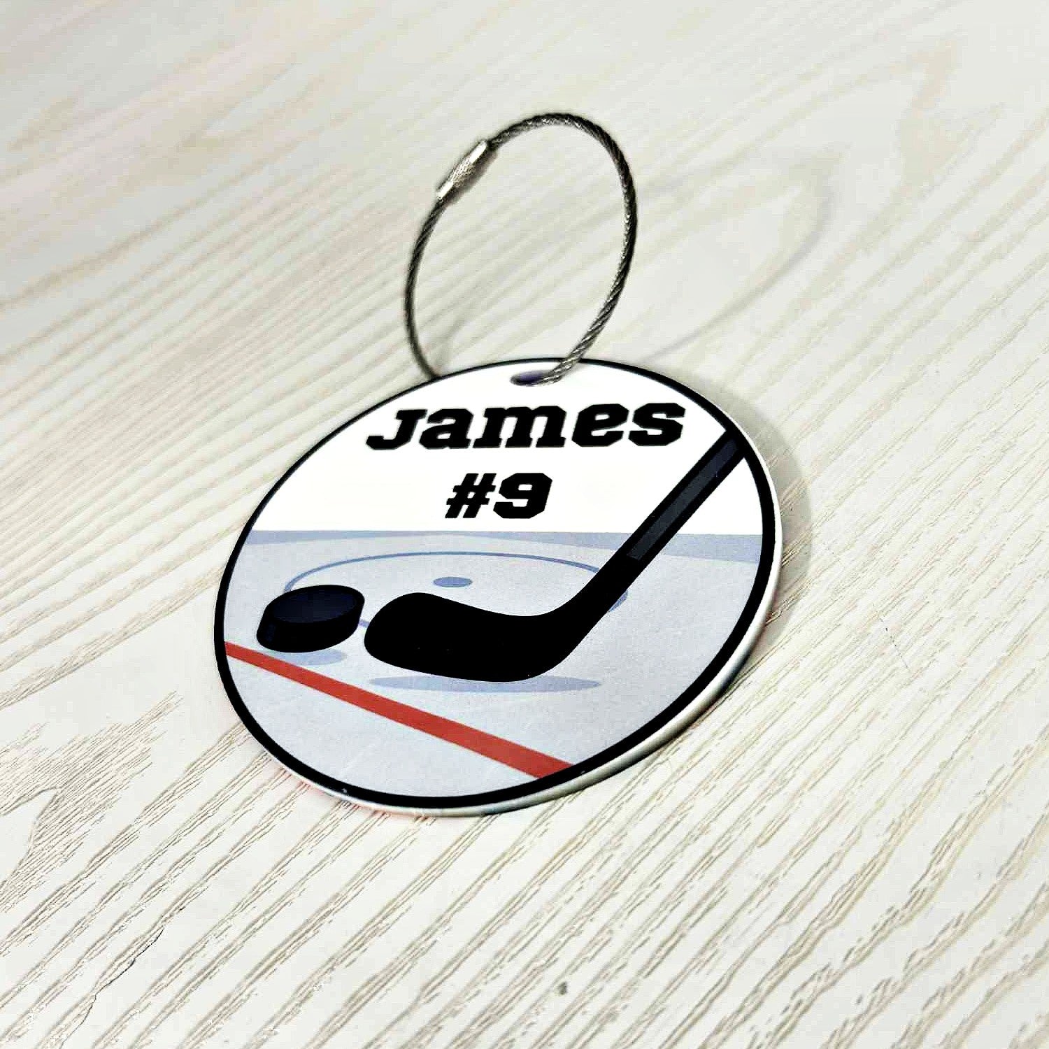 side-view-round-hockey-bag-tag-personalized-with-name-and-number-featuring-stick-and-puck