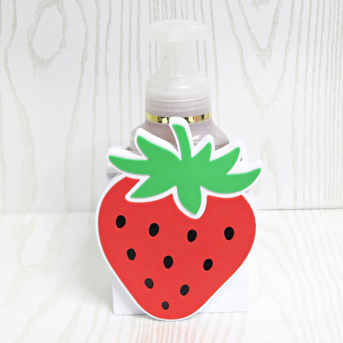 Strawberry shaped foaming soap bottle holder in red and green for kitchen and bathroom decor